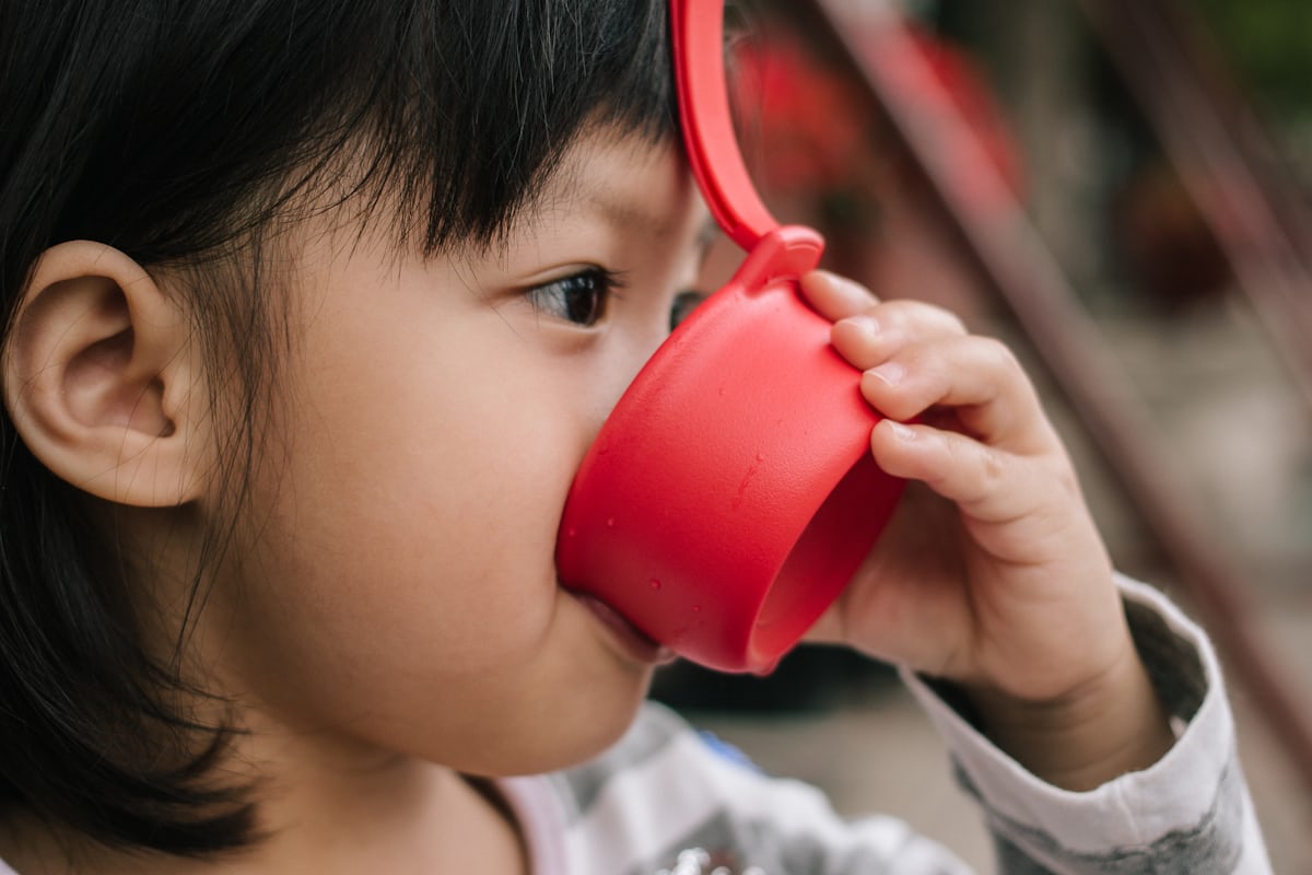 コップで水分を飲む子ども 胃腸炎の水分補給